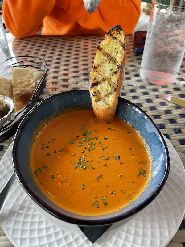 At George's Bistro and Bar Houston TX we had the tomato basil soup served in a blue bowl with a slice oar grilled garlic toast secured on the edge of the bowl.