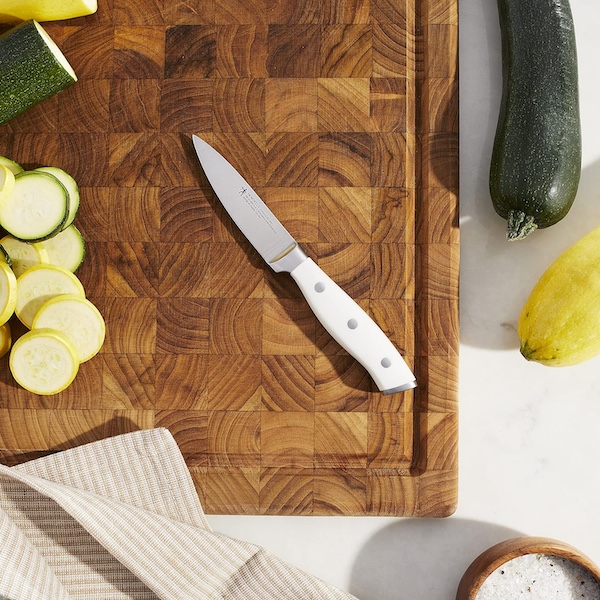 My new Henckels paring knife on a wood cutting board with sliced and whole veggies.