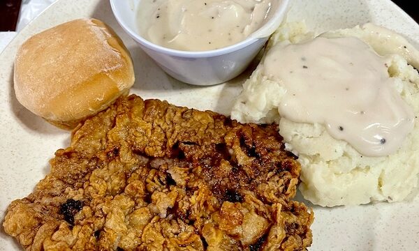 Our First Taste of Chicken Fried Steak, mashed potatoes and a cup of white gravy.