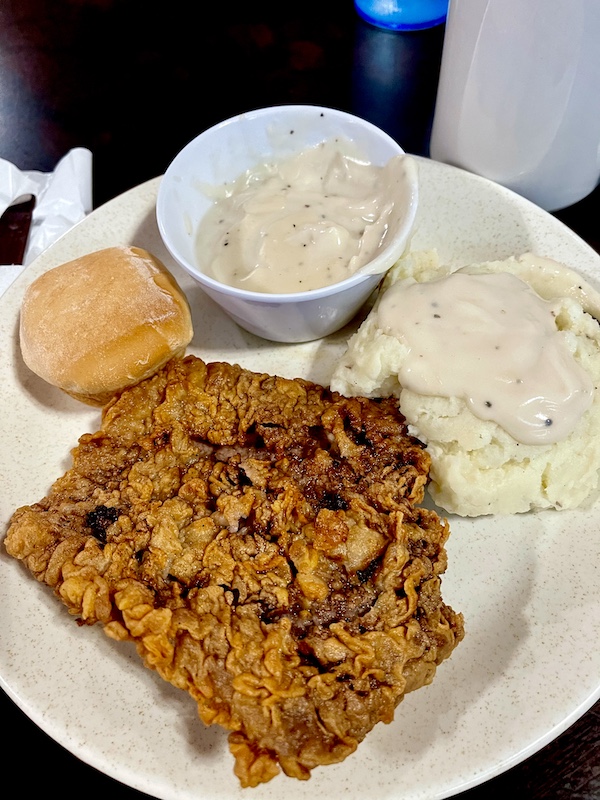 Our First Taste of Chicken Fried Steak, mashed potatoes and a cup of white gravy.