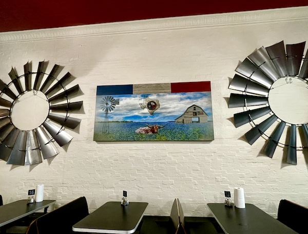 Our First Taste of Chicken Fried Steak at a restaurant with cowboy art on the walls.