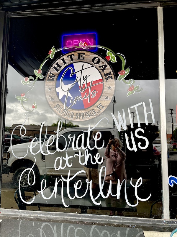 Store front window painted with logo and writing