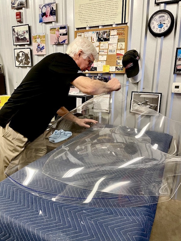 Man with white hair showing a windshield that needs repair at the Chaparral Gallery Petroleum Museum
