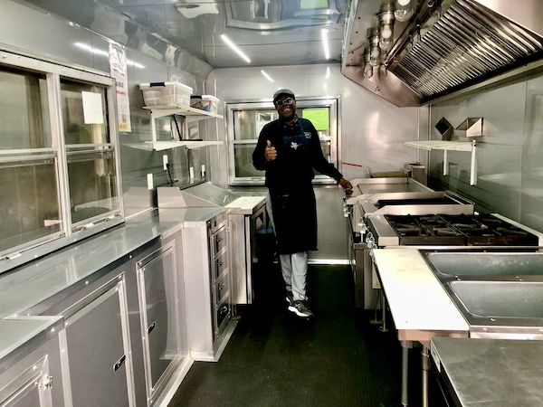 Chef showing the interior of his food truck at Get Around Brown BBQ Midland TX
