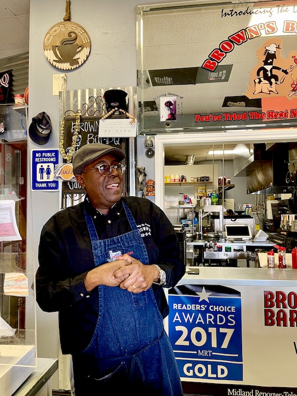 Chef with black shirt and blue apron in his restaurant Get Around Brown BBQ Midland TX