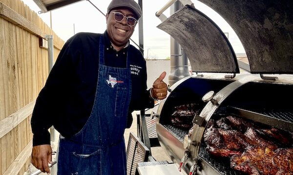 Chef standing at open smokers with meat cooking at Get Around Brown BBQ Midland TX