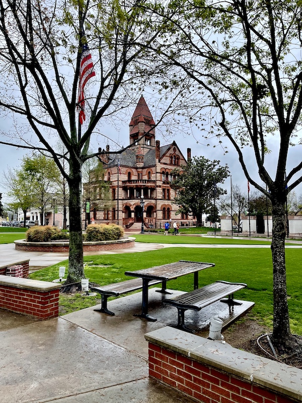 Romanesque granite and sandstone building is in same plaza as Glass Bathrooms of Sulphur Springs TX