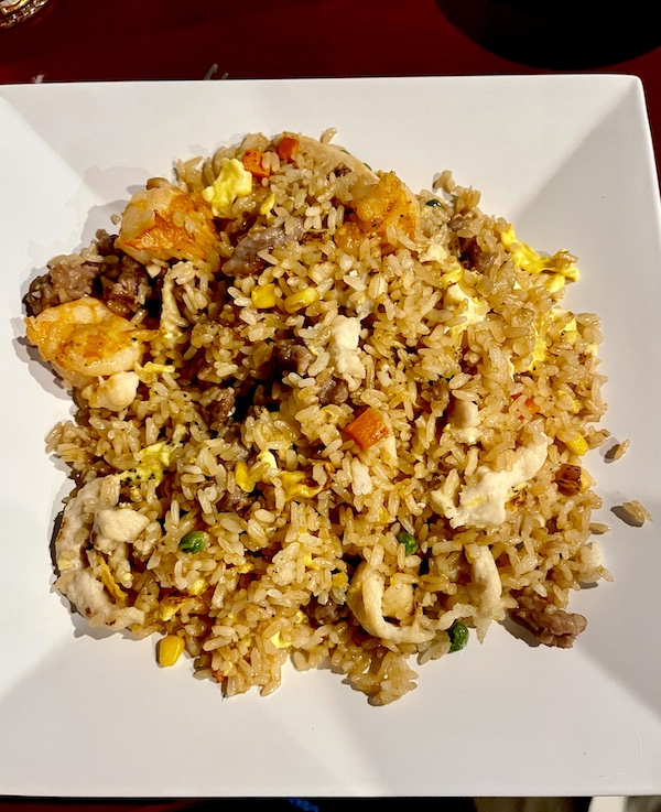 Square white dish topped with fried rice with shrimp, chicken and beef at Sakura Sushi Sulphur Springs TX