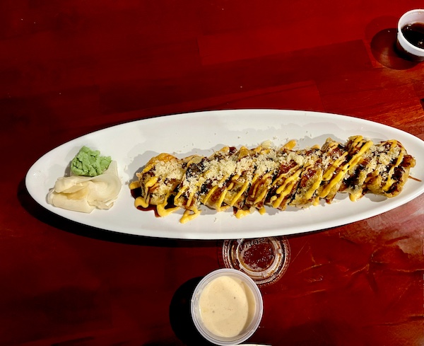 Heaven sushi roll on an oval white plate on burgundy table at Sakura Sushi Sulphur Springs TX