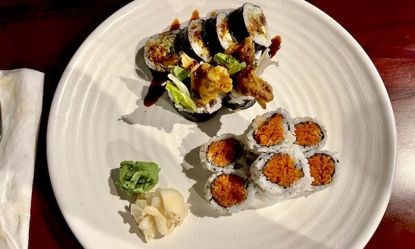 Round white plate topped with two different sushi rolls, wasabi and pickled ginger at Sakura Sushi Sulphur Springs TX