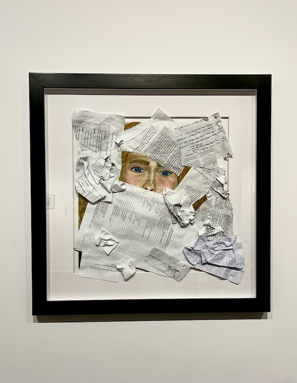 Face peeking out of torn pages of an atlas and newspapers on display at The Grace Museum Abilene TX