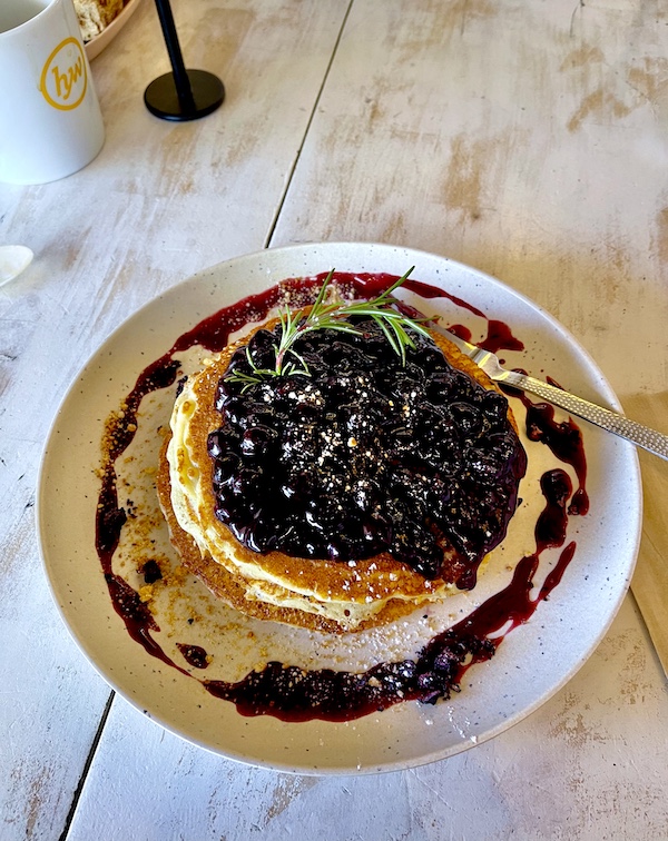 White plate topped with stack of pancakes blueberry compote and powdered sugar from a restaurant near Lake Skinner Temecula CA