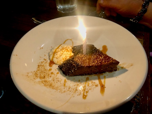 Dessert plate with chocolate heart and lit birthday candle at Locale Neighborhood Italian Tucson