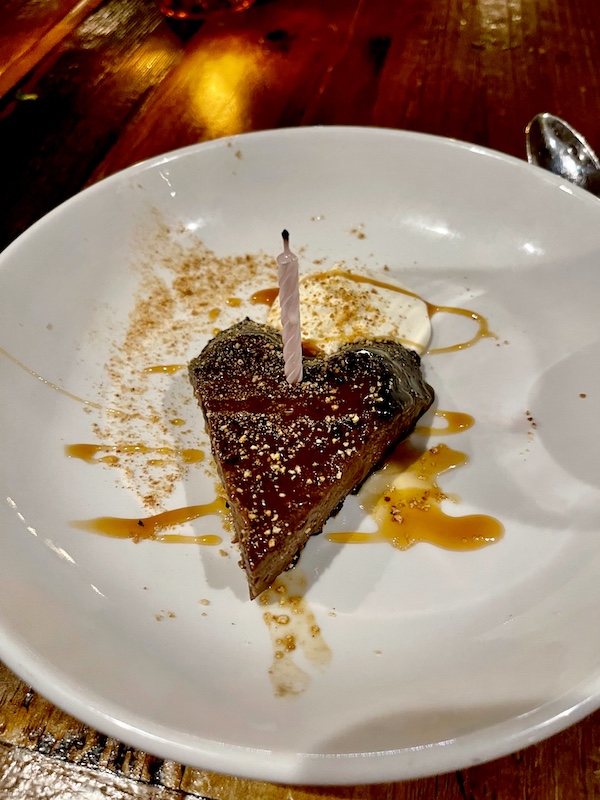 White dessert plate topped with a chocolate pudding heart at Locale Neighborhood Italian Tucson
