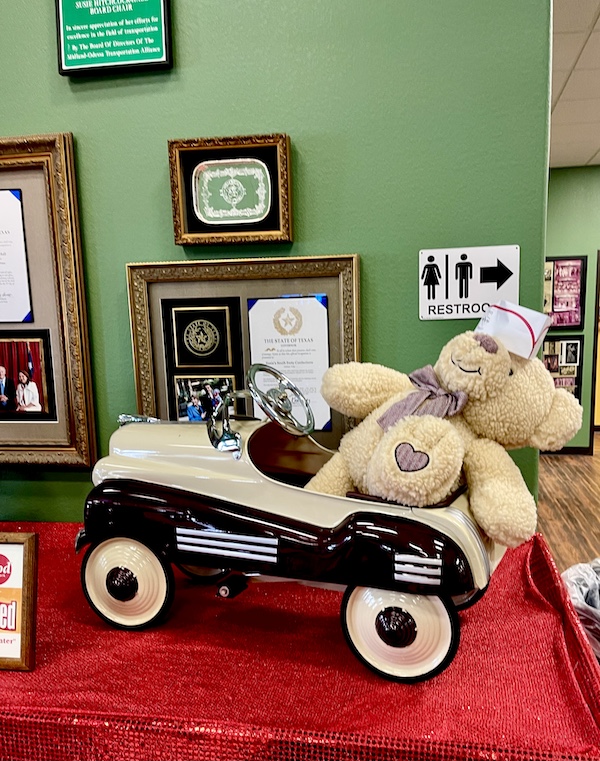Black and Cream toy car with beige stuffed teddybear on display at Susie's South Forty Midland TX