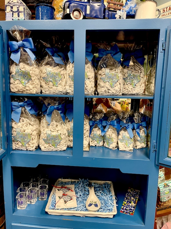 Clear bags of white chocolate candy pieces tied with blue ribbons on a blue case at Susie's South Forty Midland TX