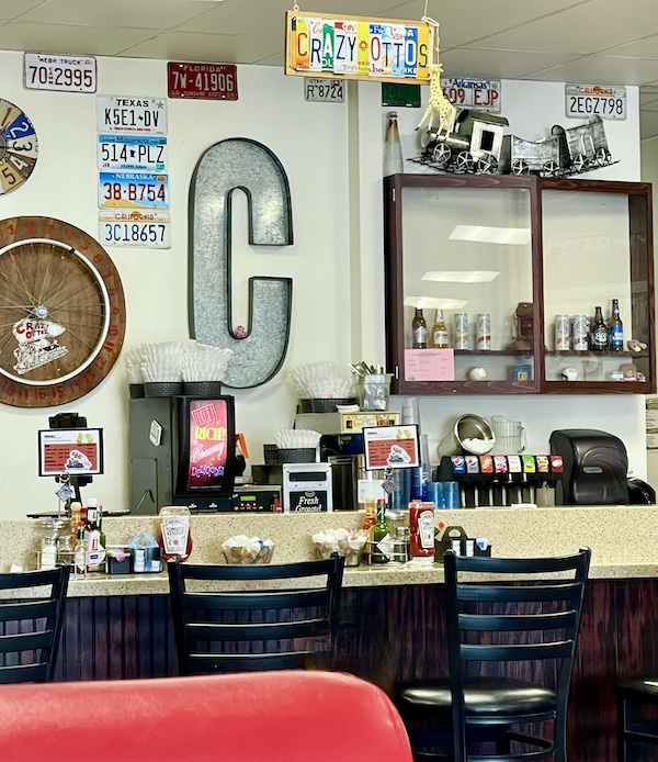 Walls of restaurant with cool memorabilia, tables and chairs seen while having Brunch at Crazy Otto's Diner