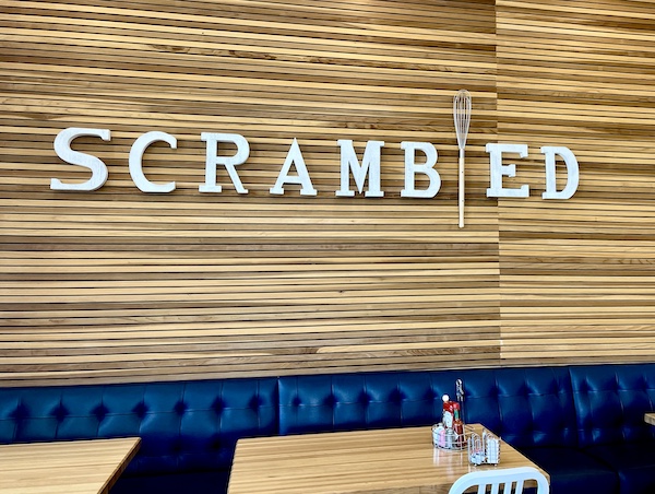 Wood wall and tables with blue banquette at Scrambled in Henderson NV where we had brunch with friends