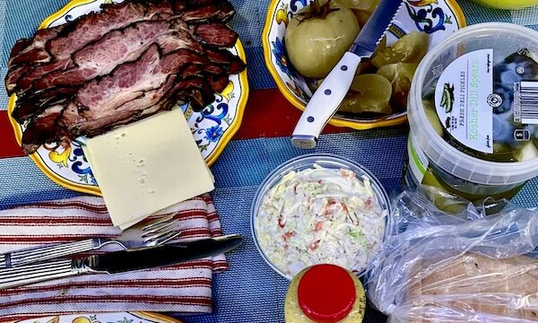 Dining table set with food from Canter's Deli on Fairfax, placemats and plates