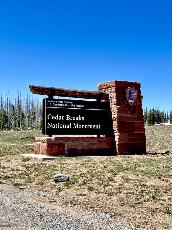 Stone pillar with wood sign welcoming you to Cedar Breaks National Monument