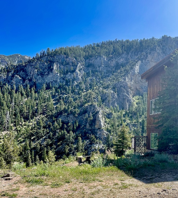 Craggy mountains, trees and a wood cabin from our day at Scenic Mount Charleston Nevada