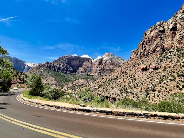Highway passed mountains with some snowy peaks at Zion National Park Utah