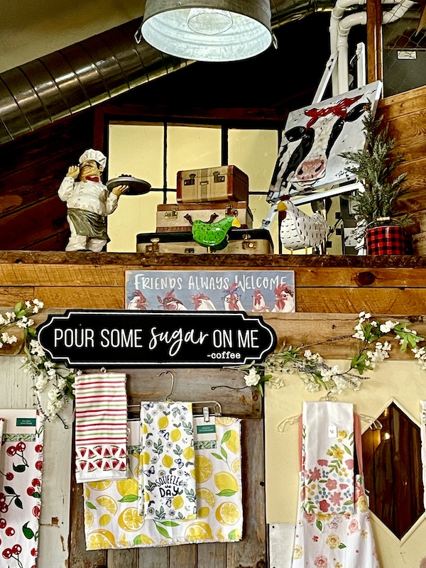 Pizza chef and other knickknacks on a shelf with tea towels below in Delightful Parowań Utah