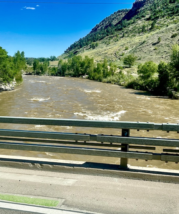 Crossing a rapid river with mountains and trees in Durango, Colorado