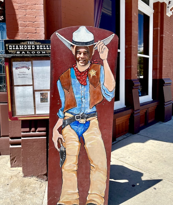 Steve behind a cutout of a cowboy with a big white cowboy had outside of Diamond Belle Saloon Durango