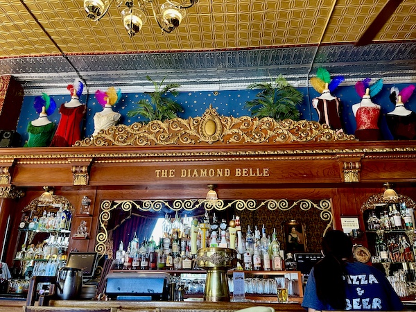 Old wooden bar with bottles of spirits at Diamond Belle Saloon Durango