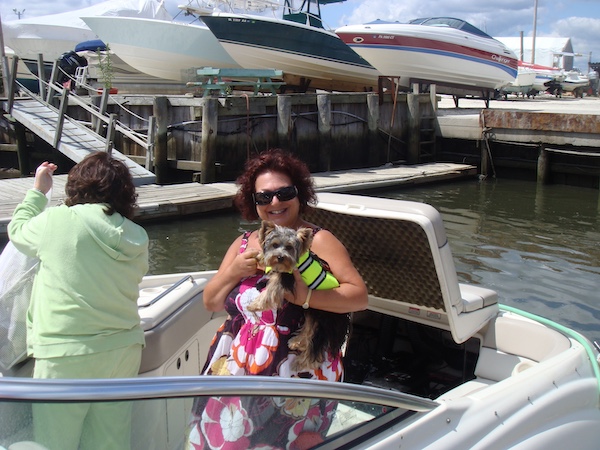 Me and Hershi with his life jacket on sitting on a speed boat.