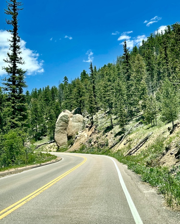 Pike's Peak Highway with rocks and trees on either side.