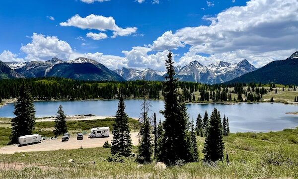 Mountain lake surrounded by trees with RVs parked seen on our Scenic Drive to Silverton and Ouray