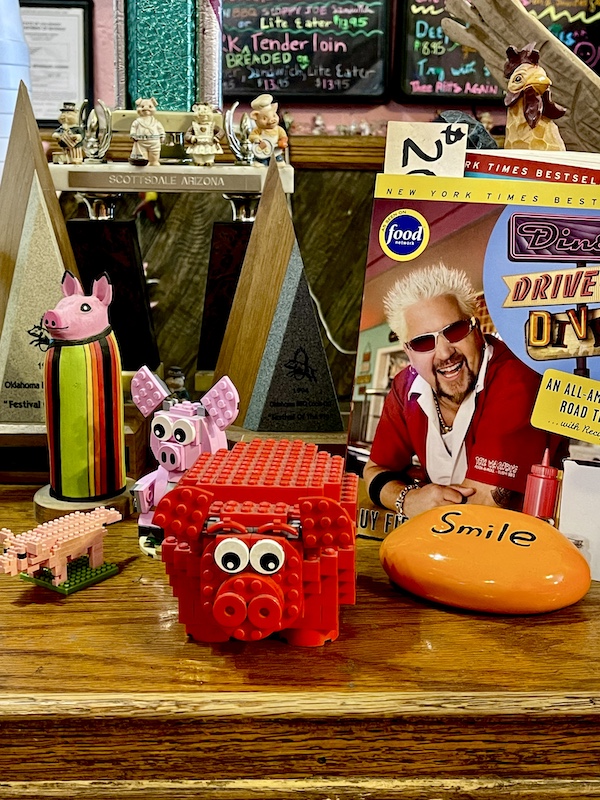 Colorful assortment of pigs made from Legos and a photo of Guy Fieri from Triple D
