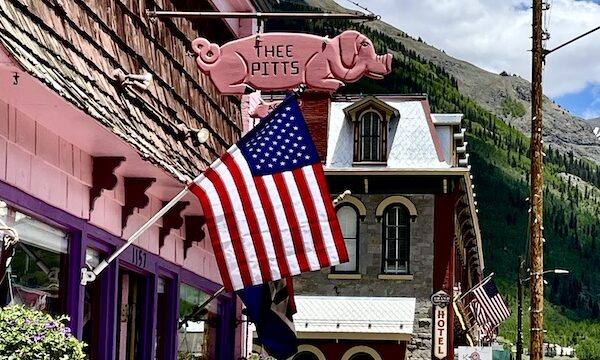 Pink building with American flag hanging houses Thee Pitts Again BBQ in Silverton CO