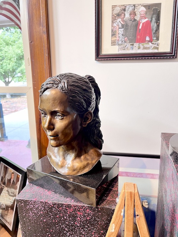 Bronze bust of a young girl on black marble rectangle at Sondra Jonson's studio
