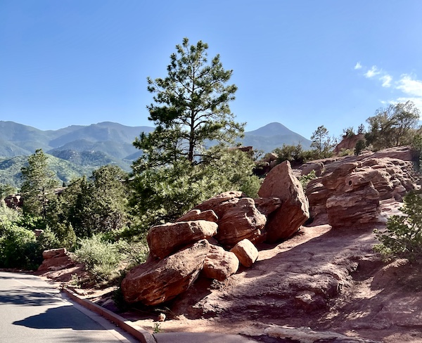Pretty rock formations and trees with mountains in the background.