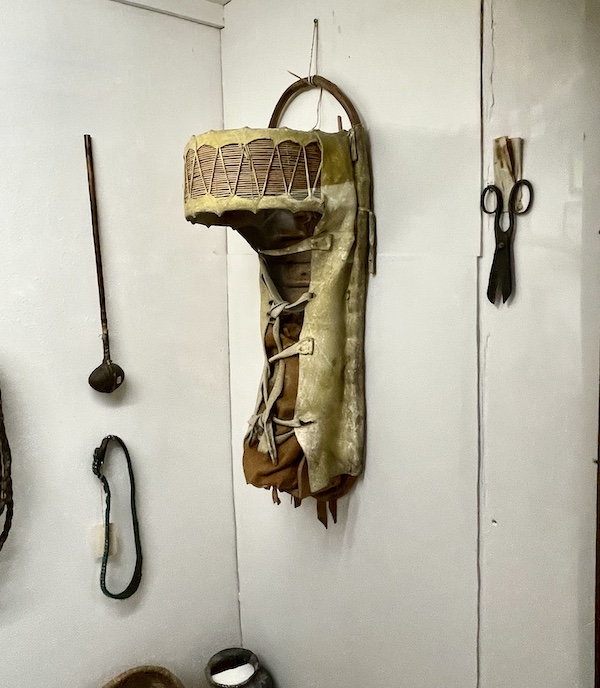 Papoose and other items displayed on a white wall at the Nebraska's Cambridge Museum