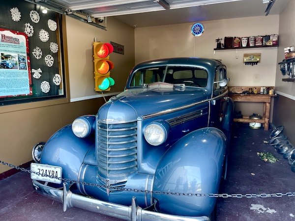 Parked across the street from The Christmas Story House is a blue 1938 Oldsmobile Touring Sedan.