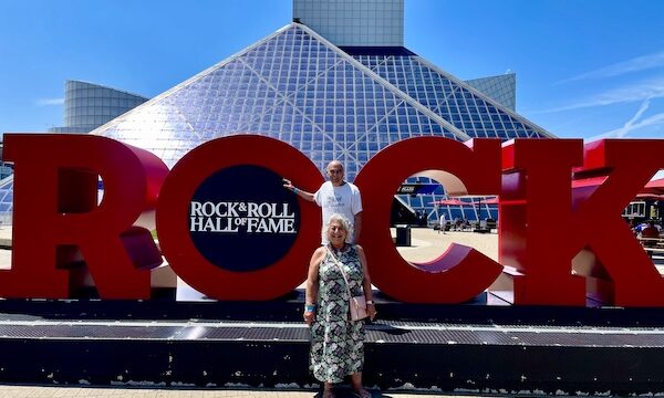 Steve and I standing in front of large red letters spelling Rock that welcome you to the Rock and Roll Hall of Fame