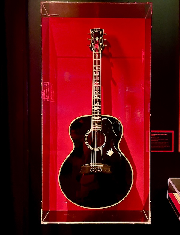Black guitar with Elvis Presley's name on red back drop at Rock and Roll Hall of Fame