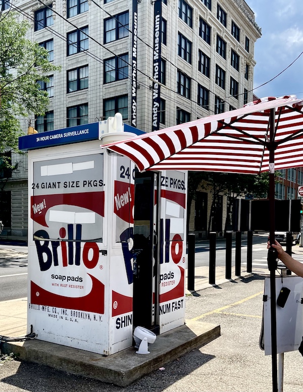 Large Brillo box, red and white striped umbrella and Andy Warhol Museum Pittsburgh in background