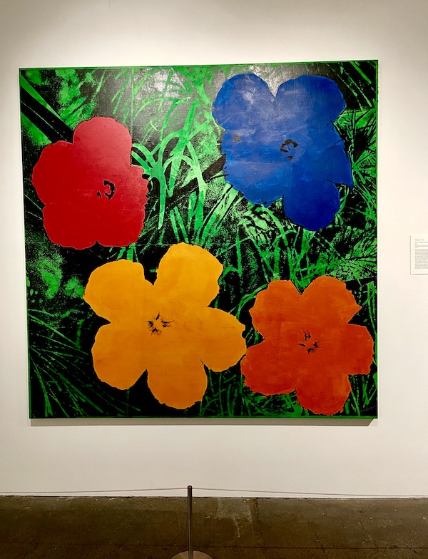 Artwork of red, yellow, blue and orange flowers with leaves on display at the Andy Warhol Museum Pittsburgh