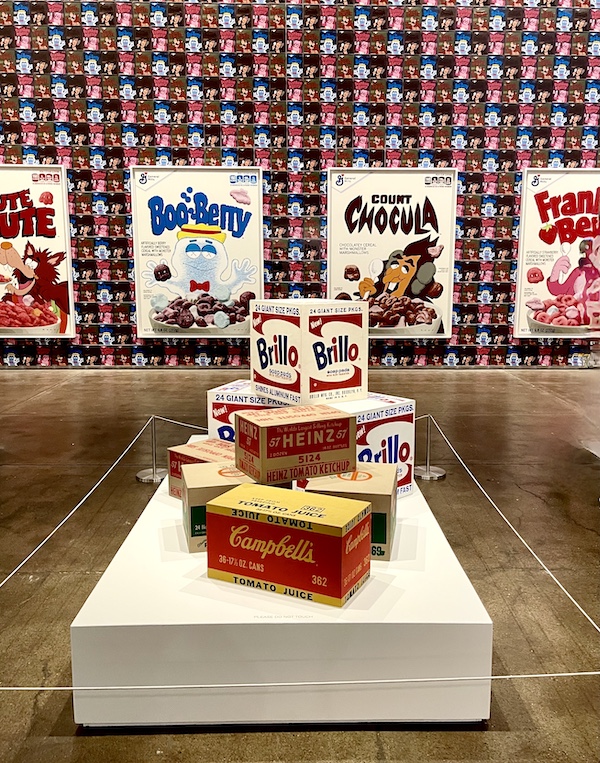 White platform with an assemblage of Brillo pad cases, Campbell's soup cases, etc. on display at the Andy Warhol Museum Pittsburgh