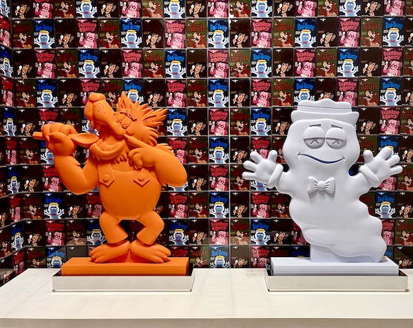 Whimsical orange and light blue characters created by Kaws to represent General Mills cereal monsters.