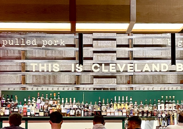 Michael Symon's Mabel's BBQ bar with deep green accent and lots of liquor bottles.