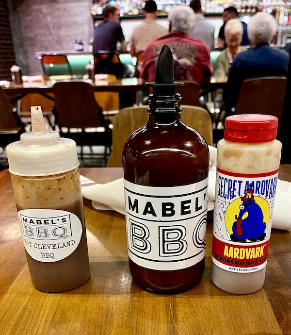Trio of sauces on a wood table at Michael Symon's Mabel's BBQ
