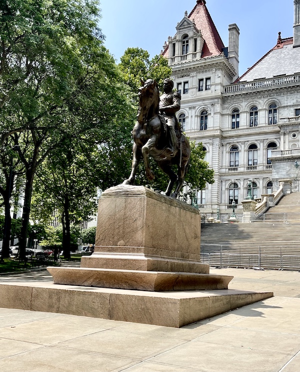 Bronze statue of General Philip Henry Sheridan on horseback with NY State Capitol in background in Upstate New York