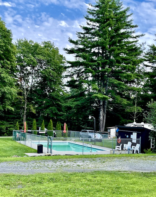 Swimming pool nestled in the trees with chain link fence around pool at campground in Upstate New York
