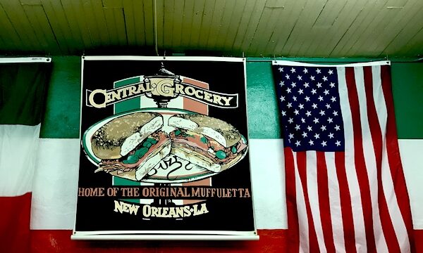 American flag and colorful sign at entry to Central Grocery before renovations.